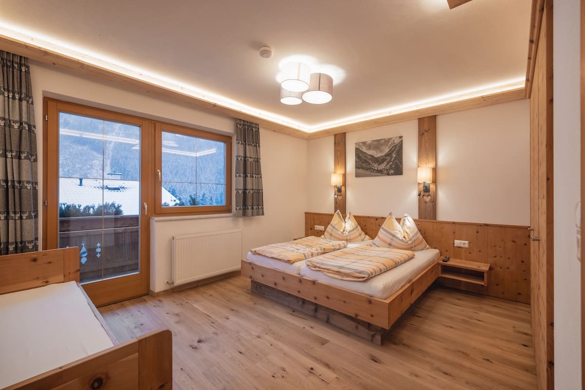 haus-alpenkoenig-laerchenwald-schlafzimmer-fenster-bergblick